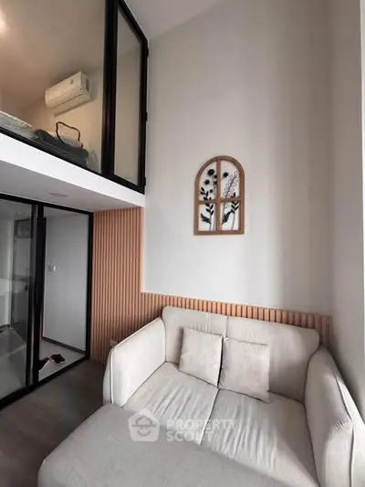 Modern loft apartment with stylish decor and cozy seating area, featuring high ceilings and contemporary design.
