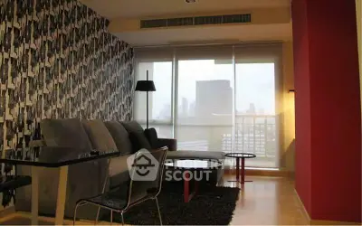 Modern living room with city view, stylish wallpaper, and cozy seating area.