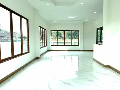 Spacious and bright living room with large windows and glossy floors.