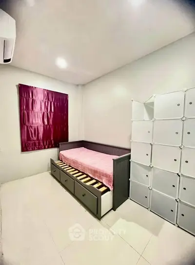 Modern minimalist bedroom with sleek storage solutions and cozy bed setup.