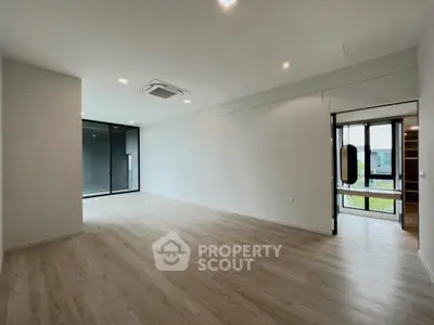Spacious modern living room with large windows and wooden flooring