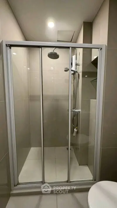 Modern bathroom with sleek shower enclosure and overhead rain shower.