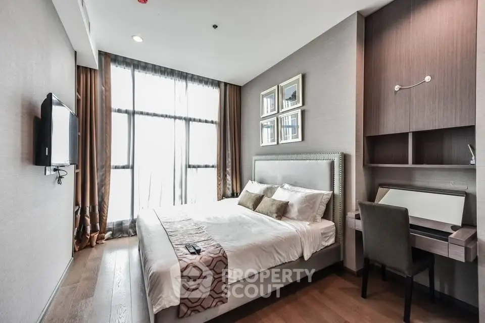 Modern bedroom with large window, stylish decor, and workspace in luxury apartment.