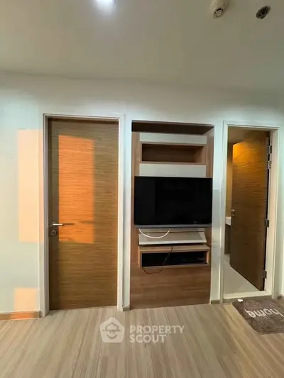 Modern living room with built-in TV unit and wooden doors, perfect for cozy entertainment.