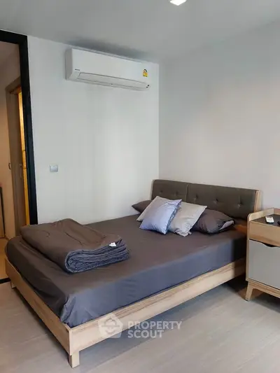Modern bedroom with stylish bed and air conditioning unit, perfect for comfort and relaxation.