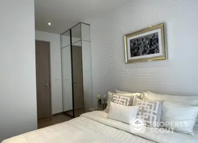 Modern bedroom with stylish decor and mirrored wardrobe in elegant apartment.