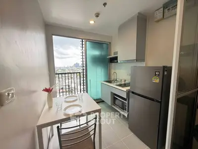 Modern kitchen with balcony view, featuring sleek appliances and dining area in a compact layout.