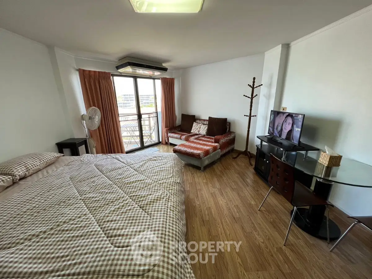 Spacious studio apartment with cozy living area and balcony access