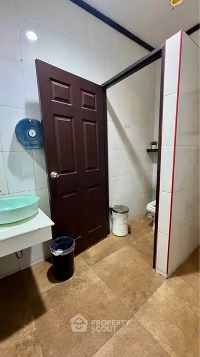 Compact bathroom with modern fixtures and brown door