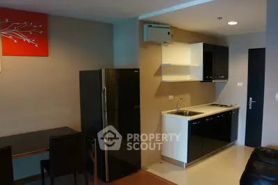 Modern kitchen with sleek black cabinets and appliances in a stylish apartment.