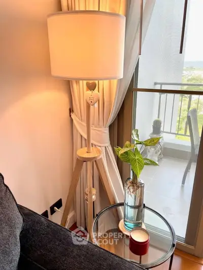 Cozy living room corner with stylish floor lamp and balcony view.