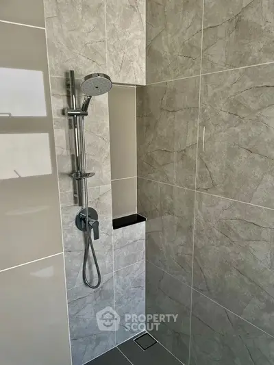 Modern bathroom with sleek shower design and elegant gray tiles.
