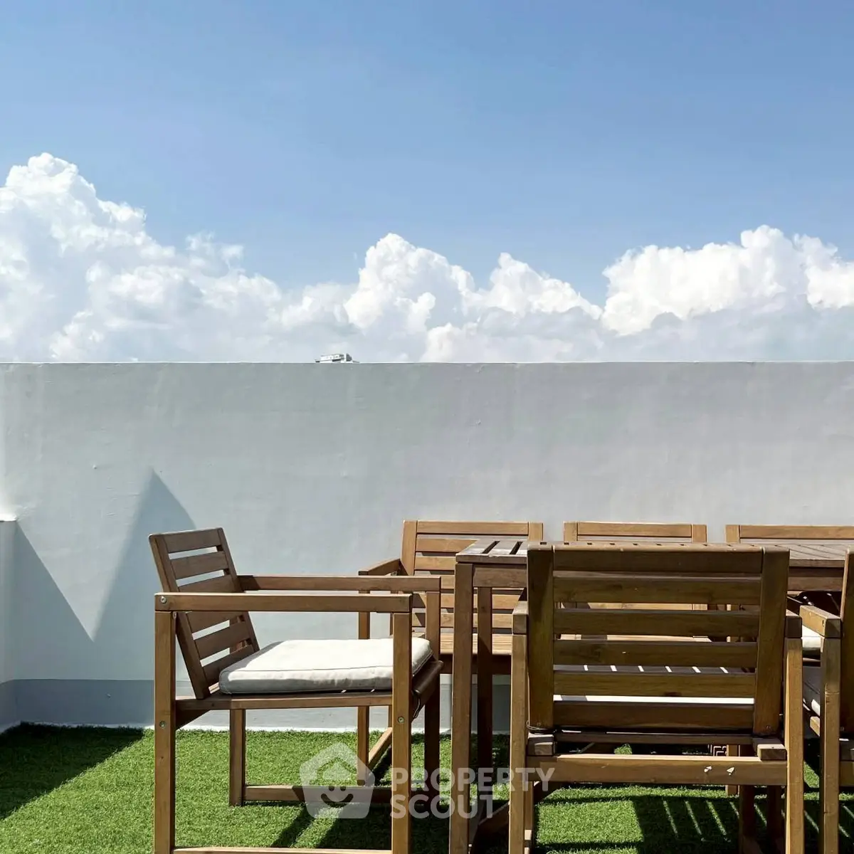 Charming rooftop terrace with wooden furniture and stunning sky view.
