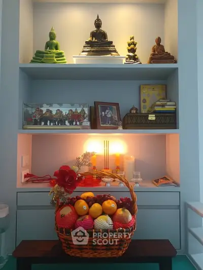 Elegant home altar with Buddha statues and fruit basket in serene living space.