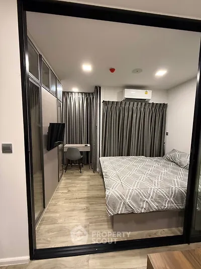 Modern bedroom with stylish decor and workspace in a contemporary apartment.