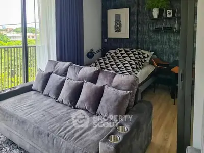 Stylish modern living room with plush gray sofa and cozy bed, perfect for urban living.