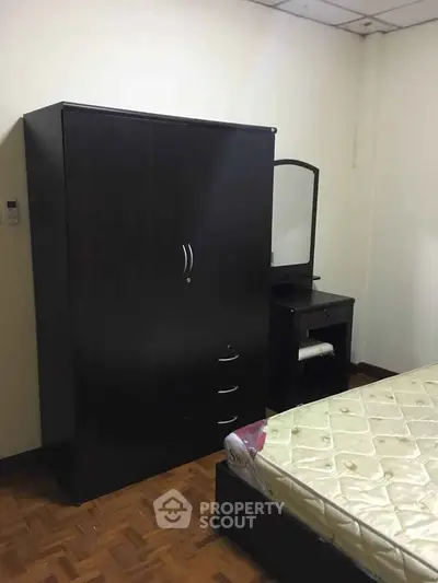 Cozy bedroom with wardrobe and dresser, perfect for comfortable living.