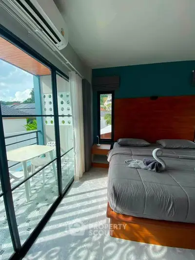 Modern bedroom with balcony access and stylish decor in a bright, airy space.
