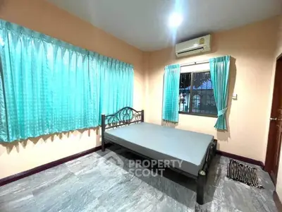 Spacious bedroom with large windows and air conditioning in a modern home.