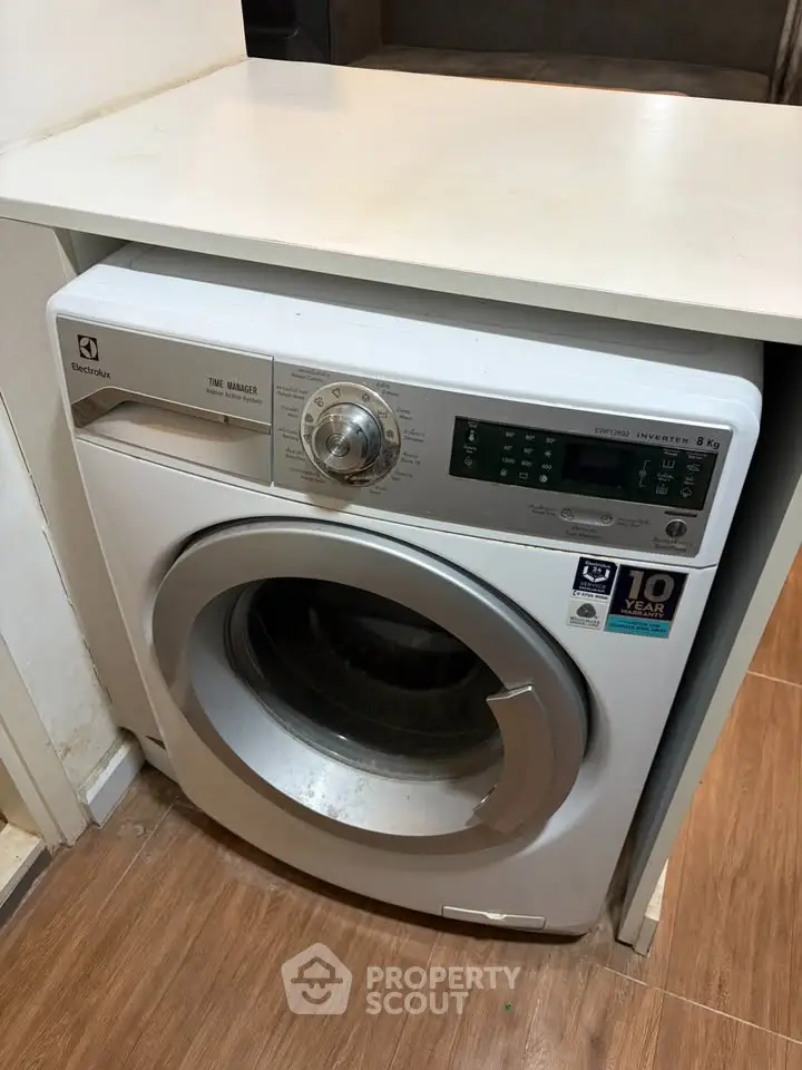 Modern washing machine in a sleek laundry area with wooden flooring, perfect for efficient home living.