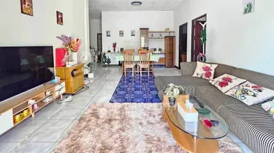 Spacious living room with modern decor and cozy seating area, perfect for family gatherings.