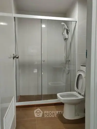 Modern bathroom with glass shower enclosure and sleek white fixtures.