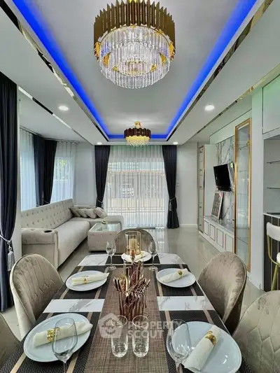 Luxurious dining and living area with elegant chandelier and modern decor