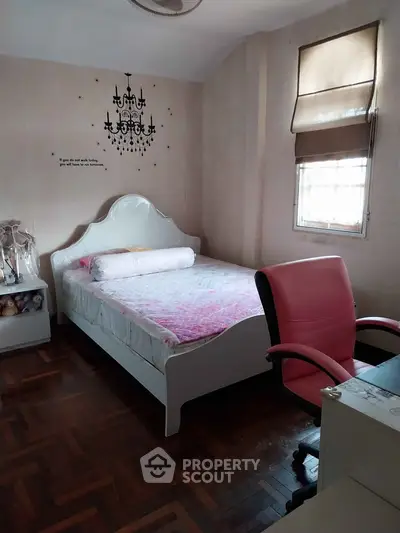 Cozy bedroom with stylish decor and parquet flooring, featuring a comfortable bed and modern office chair.