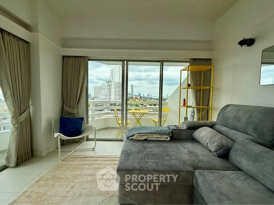 Spacious living room with city view and modern furniture in high-rise apartment