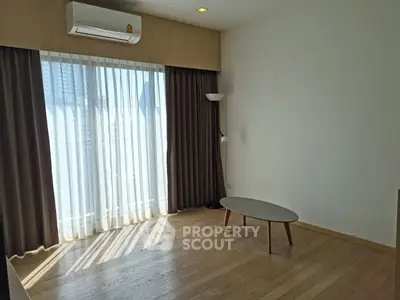 Bright living room with large window, air conditioning, and modern decor.