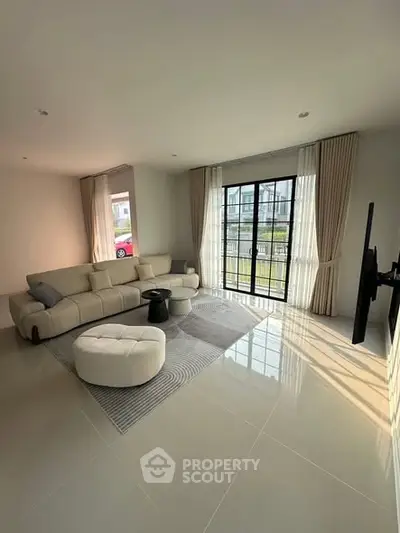 Spacious modern living room with large windows and elegant furnishings