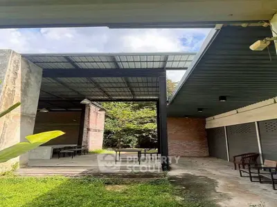 Spacious outdoor area with covered patio and lush greenery, perfect for gatherings.