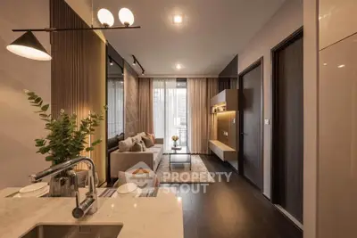 Modern living room with open kitchen, elegant decor, and natural light from large windows.