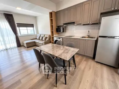 Modern open-plan kitchen and living area with stylish furniture and natural light.