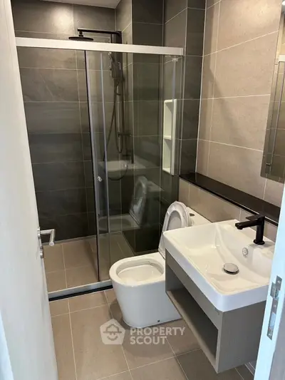 Modern bathroom with sleek shower and stylish fixtures in contemporary apartment.