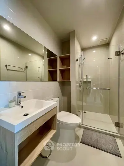 Modern bathroom with sleek design, glass shower, and elegant fixtures.