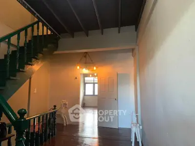 Charming interior hallway with wooden floors and staircase, featuring unique lighting and decor.