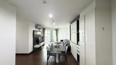 Modern living room with sleek dining area and large windows in a stylish apartment.