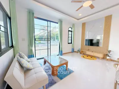 Bright and airy living room with modern decor and large windows offering garden views.