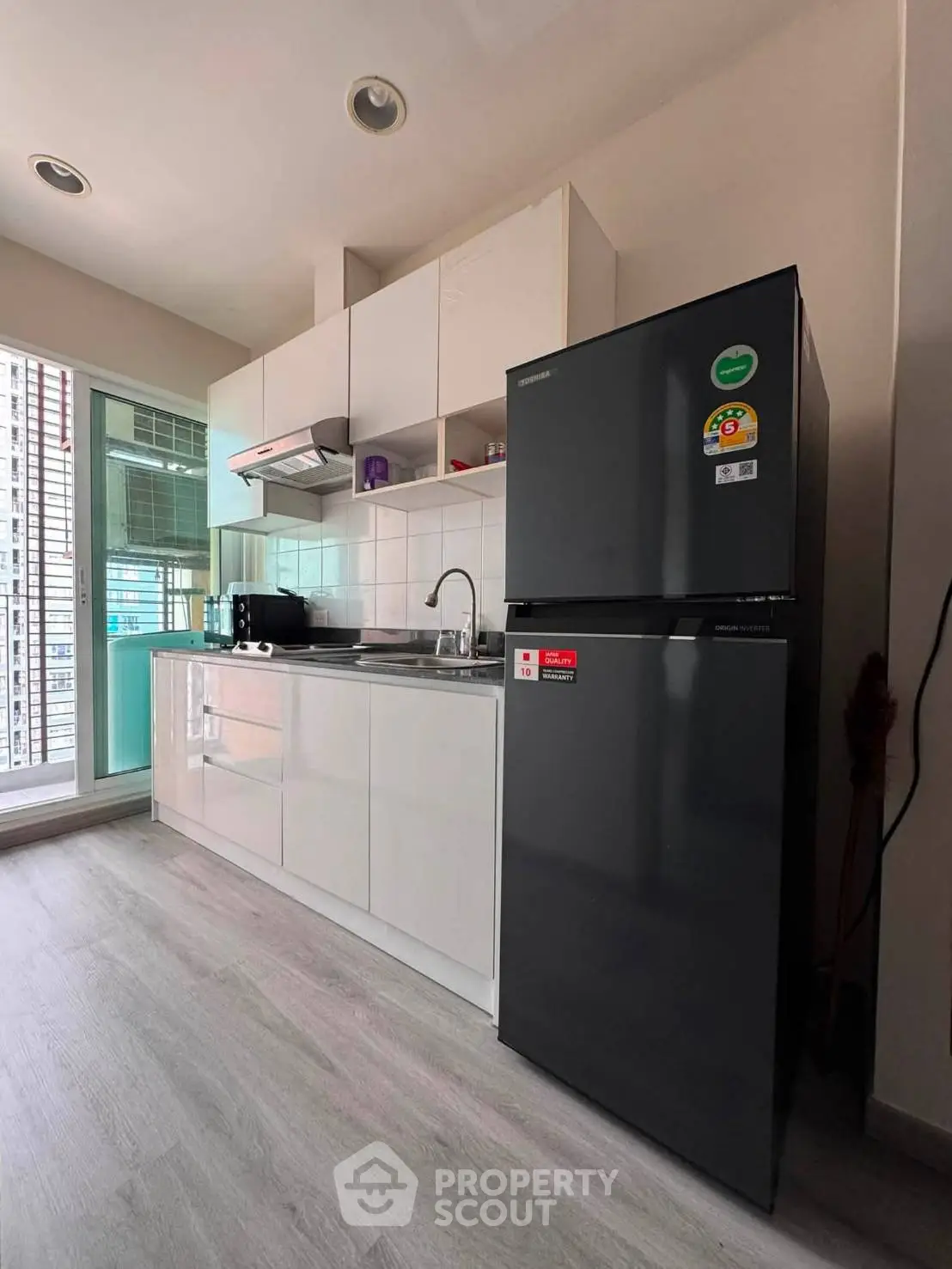 Modern kitchen with sleek cabinetry and stainless steel appliances in a bright apartment.