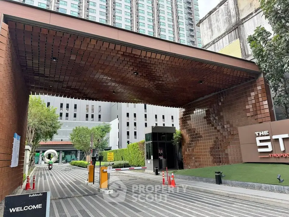 Modern building entrance with unique architectural design and lush greenery