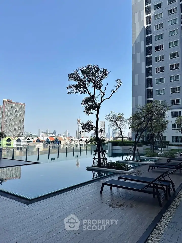 Luxurious high-rise building with stunning poolside view and cityscape backdrop.