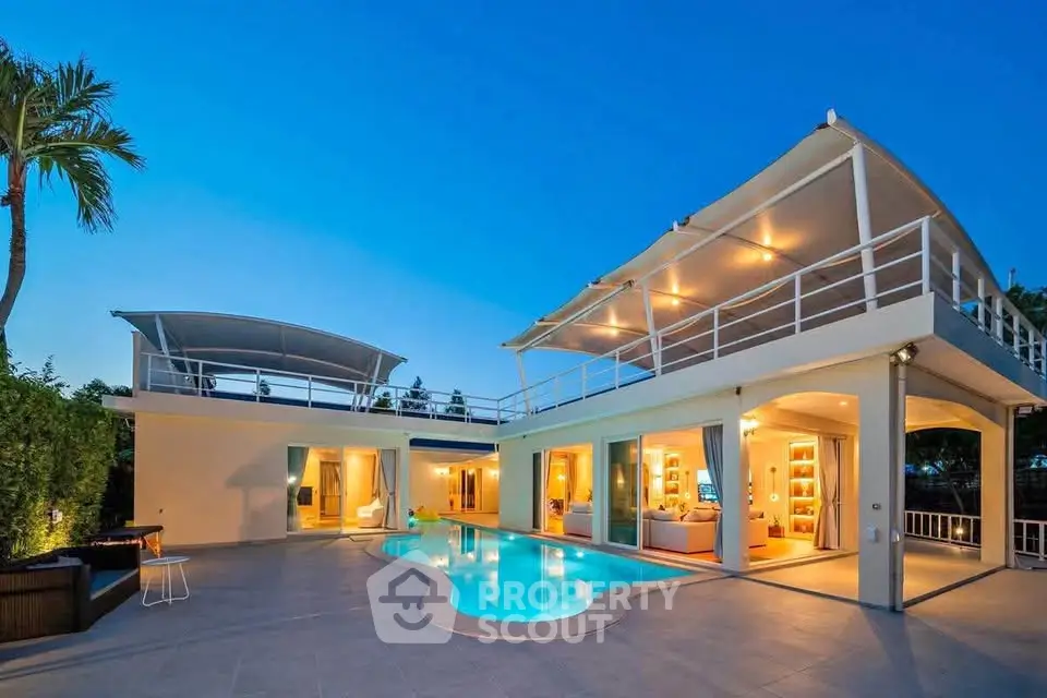 Luxurious modern villa with pool and spacious terrace at sunset, perfect for upscale living.