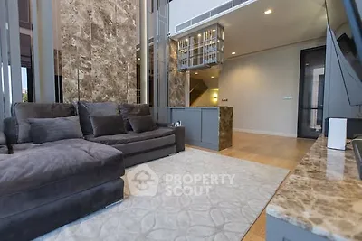 Luxurious living room with plush sofa and marble accents in modern apartment.