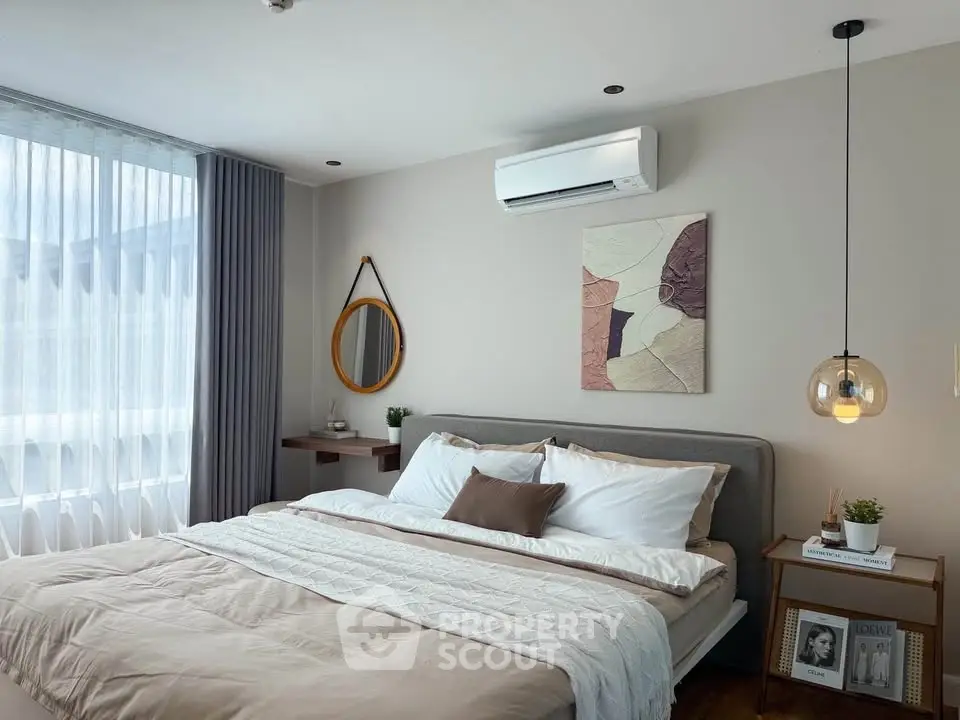 Modern bedroom with stylish decor, featuring a cozy bed, air conditioning, and elegant lighting.