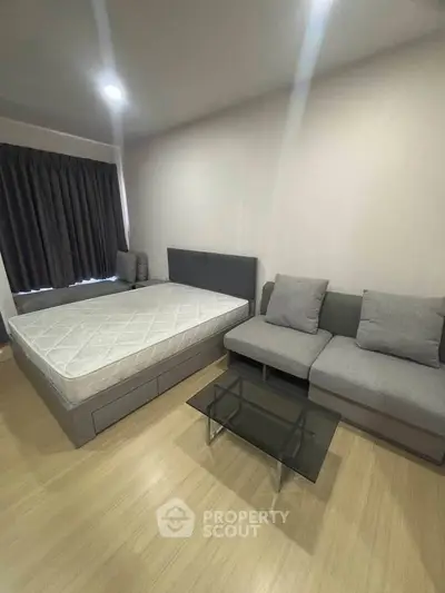 Modern bedroom with cozy sofa and glass coffee table, perfect for urban living.