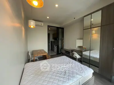 Modern studio apartment with bed, dining area, and mirrored wardrobe