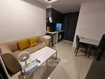 Modern living room with cozy sofa and compact kitchen in open layout apartment.