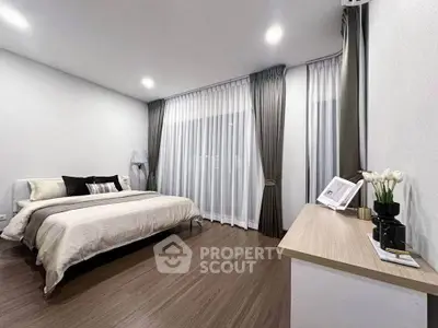 Spacious modern bedroom with elegant decor and large windows.