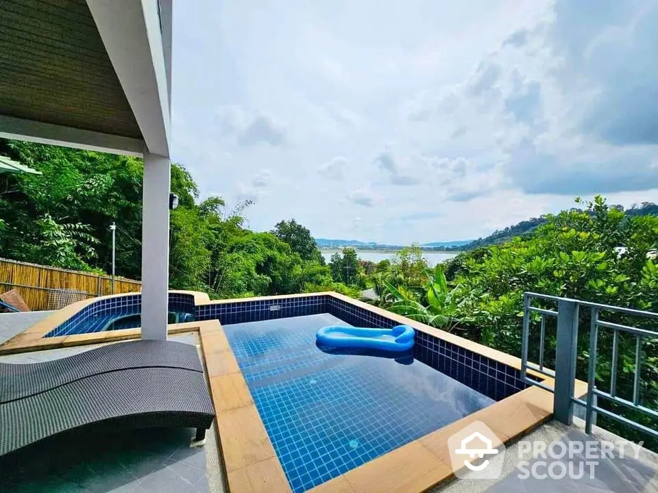 Stunning poolside view with lush greenery and ocean backdrop, perfect for luxury living.